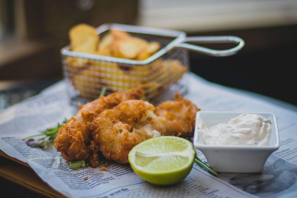 Battered and fried fish fillets with lime and tartar sauce garnish