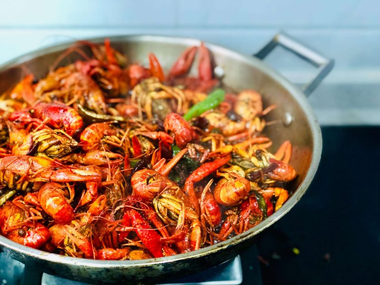 A mix of cooked seafood and vegetables in a pan
