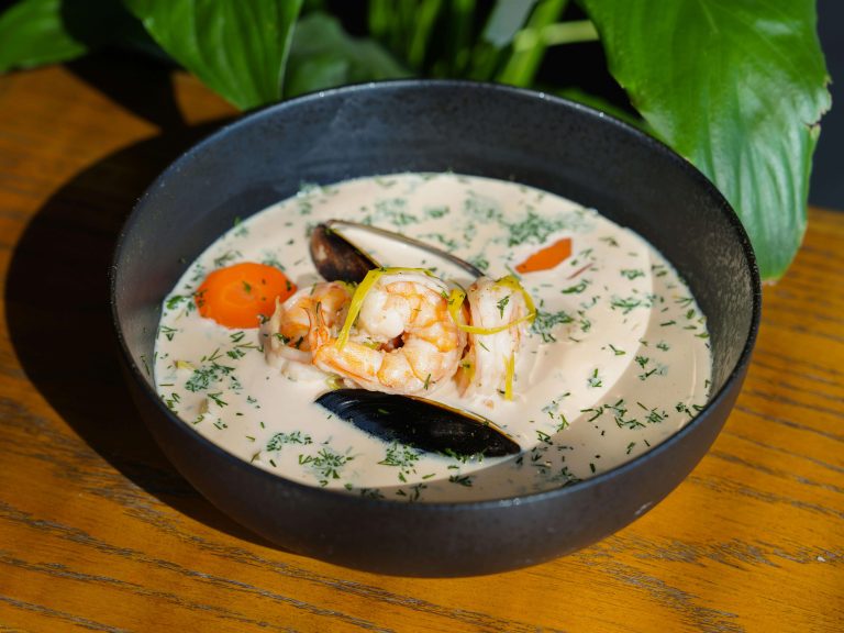 A cream based soup with seafood and vegetables, seasoned with herbs