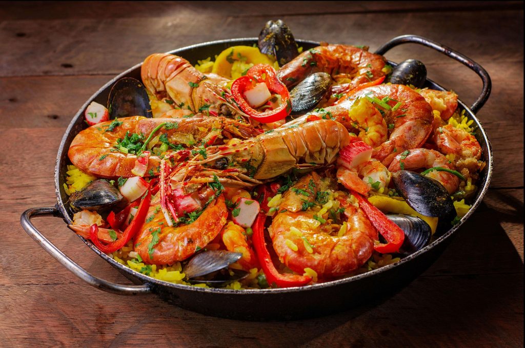 A dish of seasoned rice, seafood, and vegetables